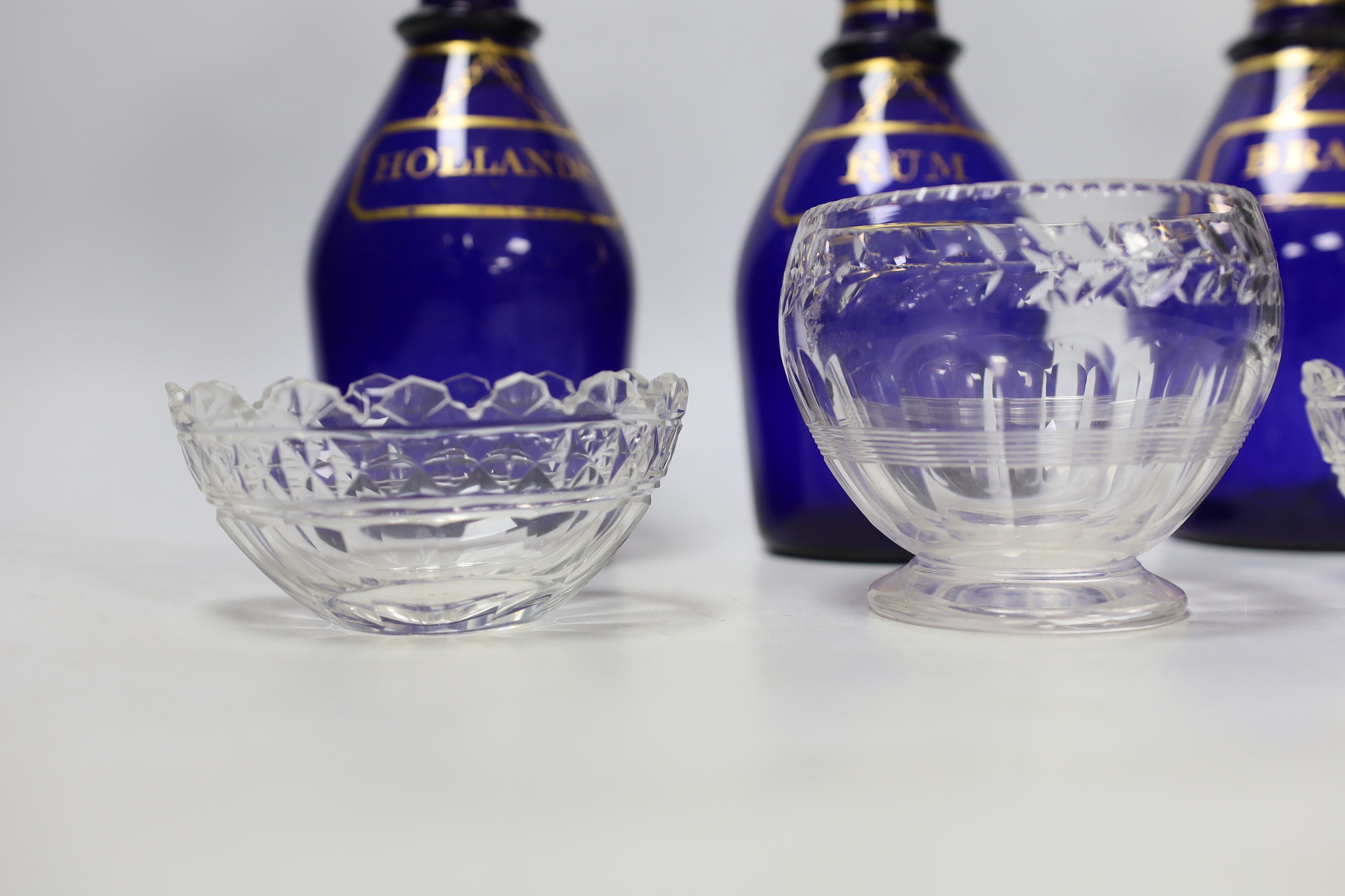 A set of three George III Bristol blue glass decanters, 25cm, and three small 19th century cut glass bowls